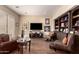 Relaxing living room featuring built-in shelving, wood floors, comfortable seating, and large windows for natural light at 20532 W Summit Pl, Buckeye, AZ 85396