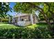 Expansive backyard featuring covered patio, outdoor kitchen, lush greenery, and manicured lawn at 210 E Cactus Wren Dr, Phoenix, AZ 85020