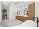 A luxury bathroom features dual sinks, modern lighting, a soaking tub, and marble floors at 210 E Cactus Wren Dr, Phoenix, AZ 85020