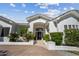 Elegant home entrance with a white brick facade, arched entryway, and landscaped garden at 210 E Cactus Wren Dr, Phoenix, AZ 85020