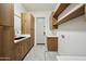 An organized laundry room offering plenty of cabinets, countertop space, and hanging storage at 210 E Cactus Wren Dr, Phoenix, AZ 85020