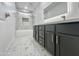 Bathroom boasts marble-patterned tiles, dark vanity cabinets, and a sleek, illuminated mirror at 22261 W Tonto St, Buckeye, AZ 85326