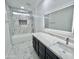 Bright bathroom features marble-patterned tile, vanity with sleek undermount sink and an illuminated mirror at 22261 W Tonto St, Buckeye, AZ 85326