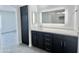Bathroom featuring dual vanity with marble counters and LED mirrors, plus dark wood cabinets at 22261 W Tonto St, Buckeye, AZ 85326