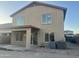 Back exterior view showcasing patio, windows, and a neutral stucco finish with outdoor AC units at 22261 W Tonto St, Buckeye, AZ 85326
