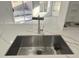 A close up view of the stainless steel kitchen sink with a designer faucet at 22261 W Tonto St, Buckeye, AZ 85326
