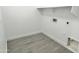 A bright and minimalist laundry room with gray-tiled flooring and white walls at 22261 W Tonto St, Buckeye, AZ 85326
