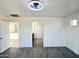 Spacious living area with a modern ceiling fan, light walls and gray wood-style flooring at 22261 W Tonto St, Buckeye, AZ 85326