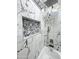 Shower with marble-patterned tiles, shower niche, and modern fixtures at 22261 W Tonto St, Buckeye, AZ 85326