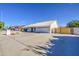 Single-story home with a white tile roof, a two-car garage, and a spacious driveway at 2317 E Lynwood St, Mesa, AZ 85213