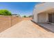Sunny backyard featuring a covered patio and high brick wall for privacy at 24580 N 144Th Ave, Surprise, AZ 85387