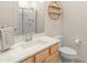Bathroom featuring a modern vanity with light wood cabinets, a neutral countertop, a shower and a circular wooden shelf at 24580 N 144Th Ave, Surprise, AZ 85387