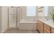 Bright bathroom features a walk-in shower, a soaking tub, and a double sink at 24580 N 144Th Ave, Surprise, AZ 85387