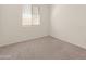 An empty bedroom features neutral carpet, white walls, a window with blinds, and electrical outlets at 24580 N 144Th Ave, Surprise, AZ 85387