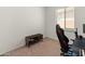 Simple bedroom features a dark brown console table and a gaming chair near a window with a neutral color palette at 24580 N 144Th Ave, Surprise, AZ 85387