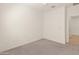 Empty bedroom features neutral carpet, white walls, a ceiling fan, an open doorway, and electrical outlets at 24580 N 144Th Ave, Surprise, AZ 85387