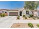 Charming single-story home featuring a well-manicured front yard with desert landscaping and a two-car garage at 24580 N 144Th Ave, Surprise, AZ 85387