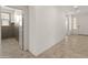 Hallway with tile flooring and an open doorway to a room with gray paneled walls and a window and doorway ahead at 24580 N 144Th Ave, Surprise, AZ 85387