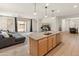 Open-concept kitchen flows into living area, featuring granite island, pendant lighting, and stainless appliances at 24580 N 144Th Ave, Surprise, AZ 85387