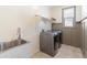 Well-lit laundry room with modern washer and dryer, sink, and wainscotting at 24580 N 144Th Ave, Surprise, AZ 85387