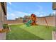 This backyard has artificial grass, wooden playset, and a trampoline at 25202 N 106Th Dr, Peoria, AZ 85383