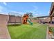 Backyard with artificial grass, trampoline, playset, and covered patio at 25202 N 106Th Dr, Peoria, AZ 85383