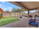 The covered patio includes a lounge area and the artificial turf has a swing set and kid toys at 25202 N 106Th Dr, Peoria, AZ 85383