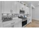 Close-up of kitchen with white countertops, stainless steel appliances, and sleek backsplash at 25202 N 106Th Dr, Peoria, AZ 85383