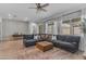 Spacious living room with a large gray sofa, wooden-style floors, and bright natural lighting at 25202 N 106Th Dr, Peoria, AZ 85383