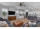 A view of a living room, featuring a sectional sofa and a view into the kitchen and breakfast bar at 25202 N 106Th Dr, Peoria, AZ 85383