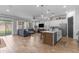 Open-concept living space with modern kitchen island and cozy seating area, perfect for entertaining and relaxation at 25202 N 106Th Dr, Peoria, AZ 85383