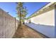 Side yard with a white home exterior, block fence, and desert-style landscaping at 2833 W Marlette Ave, Phoenix, AZ 85017