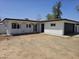 Charming single-story home featuring a well-maintained front yard, a dark two-car garage door, and a covered front porch at 2833 W Marlette Ave, Phoenix, AZ 85017
