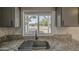 Close up shot of kitchen sink and window with granite countertops and gray cabinets at 2833 W Marlette Ave, Phoenix, AZ 85017