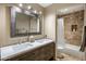 Well-lit bathroom with double vanity, large mirror, and a shower-tub combo with marble tile at 30330 N 77Th Pl, Scottsdale, AZ 85266