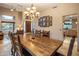 Elegant dining area boasting a large wood table, travertine floors, and stylish lighting fixtures at 30330 N 77Th Pl, Scottsdale, AZ 85266