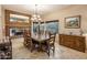 Elegant dining room with a large wooden table, decorative mirror, and natural light from the windows at 30330 N 77Th Pl, Scottsdale, AZ 85266