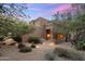 Charming Southwestern-style home with desert landscaping, accent lighting, and a welcoming entrance at 30330 N 77Th Pl, Scottsdale, AZ 85266