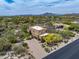 Wide aerial view of a desert home with lush landscaping, a pool, and mountain views, showcasing its scenic location at 30330 N 77Th Pl, Scottsdale, AZ 85266