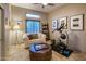 Cozy flex room featuring an elliptical machine, comfy couch, and stylish decor on travertine floors at 30330 N 77Th Pl, Scottsdale, AZ 85266