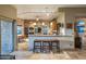 Open kitchen with breakfast bar, custom cabinets, stainless steel appliances, and access to the outdoor areas at 30330 N 77Th Pl, Scottsdale, AZ 85266