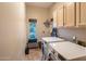 Functional laundry room with front load washer and dryer, storage cabinets and a window view at 30330 N 77Th Pl, Scottsdale, AZ 85266