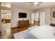 Bright main bedroom features an en-suite bathroom, wood floors, and a large television at 30330 N 77Th Pl, Scottsdale, AZ 85266