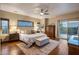 Comfortable main bedroom with wood floors, a ceiling fan, and access to a private balcony at 30330 N 77Th Pl, Scottsdale, AZ 85266