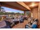 Covered outdoor patio with a fire pit and comfortable seating, overlooking a pool and desert landscape at 30330 N 77Th Pl, Scottsdale, AZ 85266
