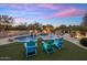 Desert oasis backyard featuring a pool with waterfall, lounge chairs, and synthetic turf at 30330 N 77Th Pl, Scottsdale, AZ 85266