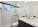 Modern bathroom with a marble walk-in shower and dark vanity with white countertop at 3202 E Orange Dr, Phoenix, AZ 85018