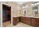 Bathroom vanity and walk-in closet with custom cabinetry and stone tile walls at 3202 E Orange Dr, Phoenix, AZ 85018