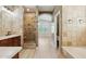 Neutral toned bathroom with stone tile walls, walk-in shower, and double shower heads at 3202 E Orange Dr, Phoenix, AZ 85018