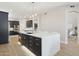 Modern kitchen with an island, dark cabinets, stainless steel appliances, and a stylish pendant light at 3202 E Orange Dr, Phoenix, AZ 85018